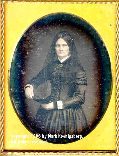 Quarter-plate daguerreotype of a Woman in Mourning Holding a Daguerreotype near Black Column 
